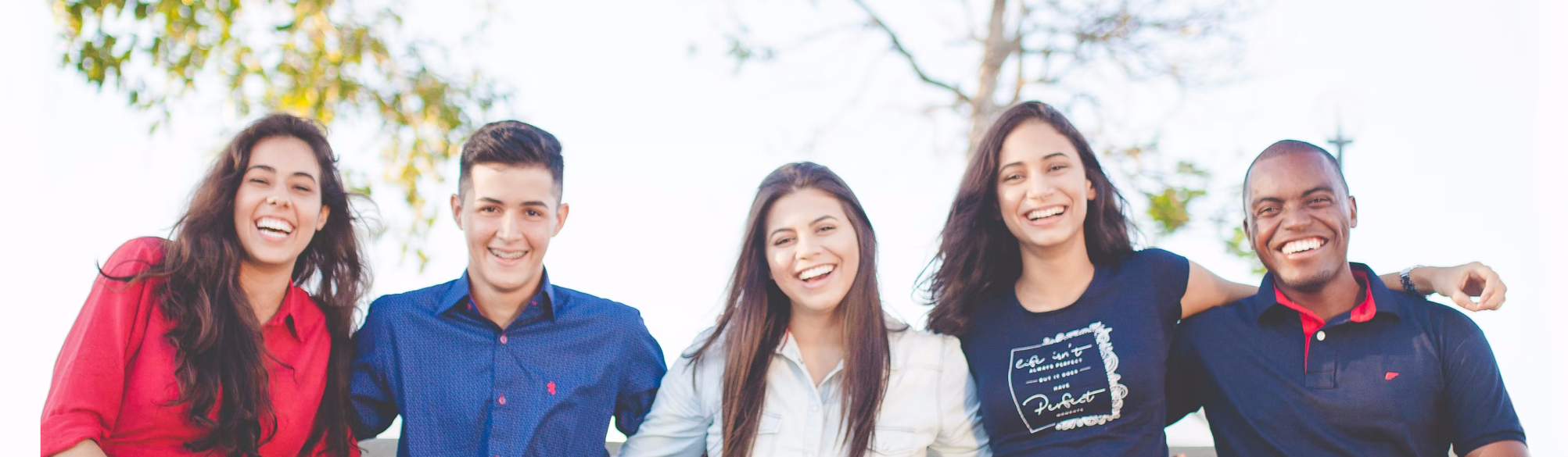 photo of five friends standing in a line outside smiling